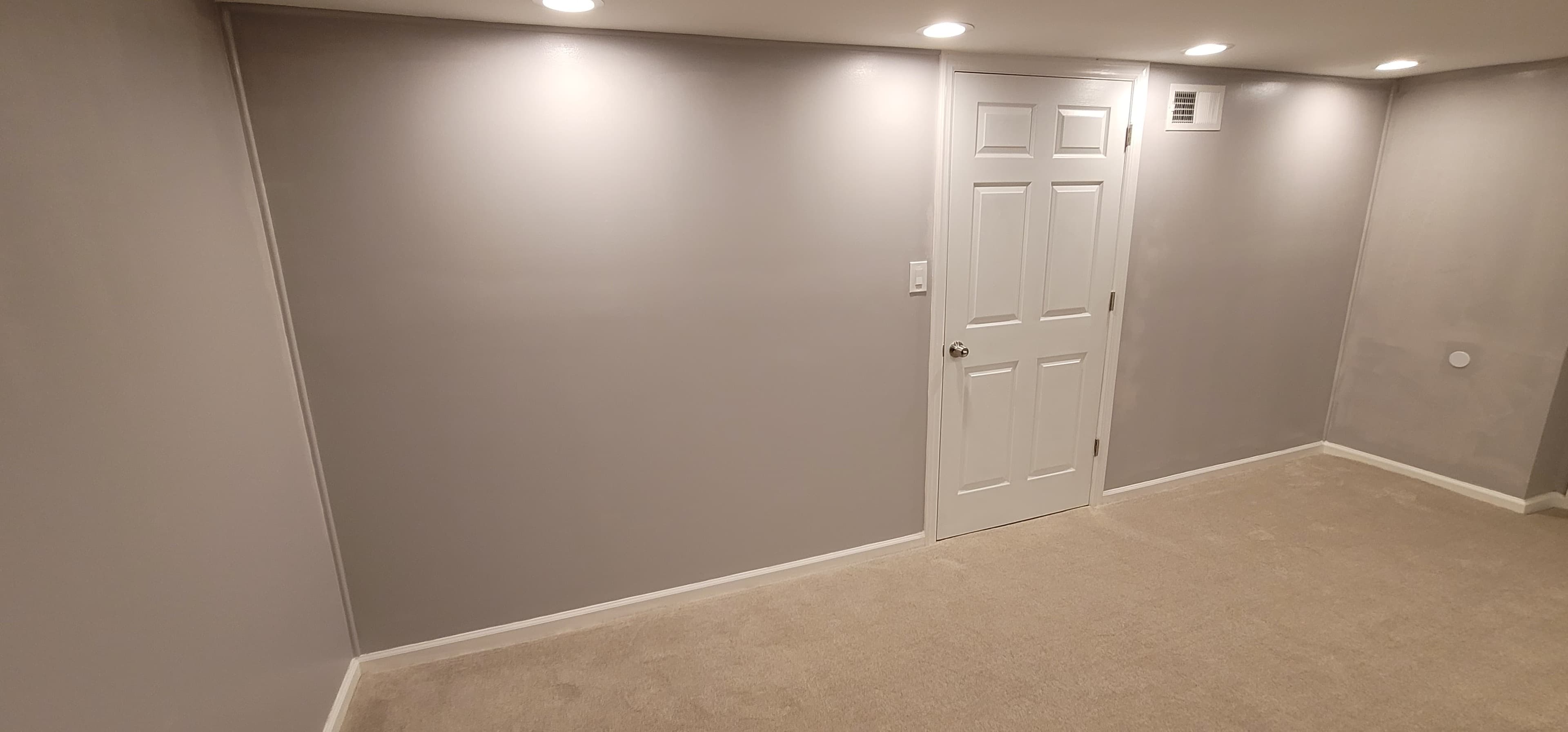 Finished basement room with gray painted walls, carpet, and recessed lighting in Rockland County NY