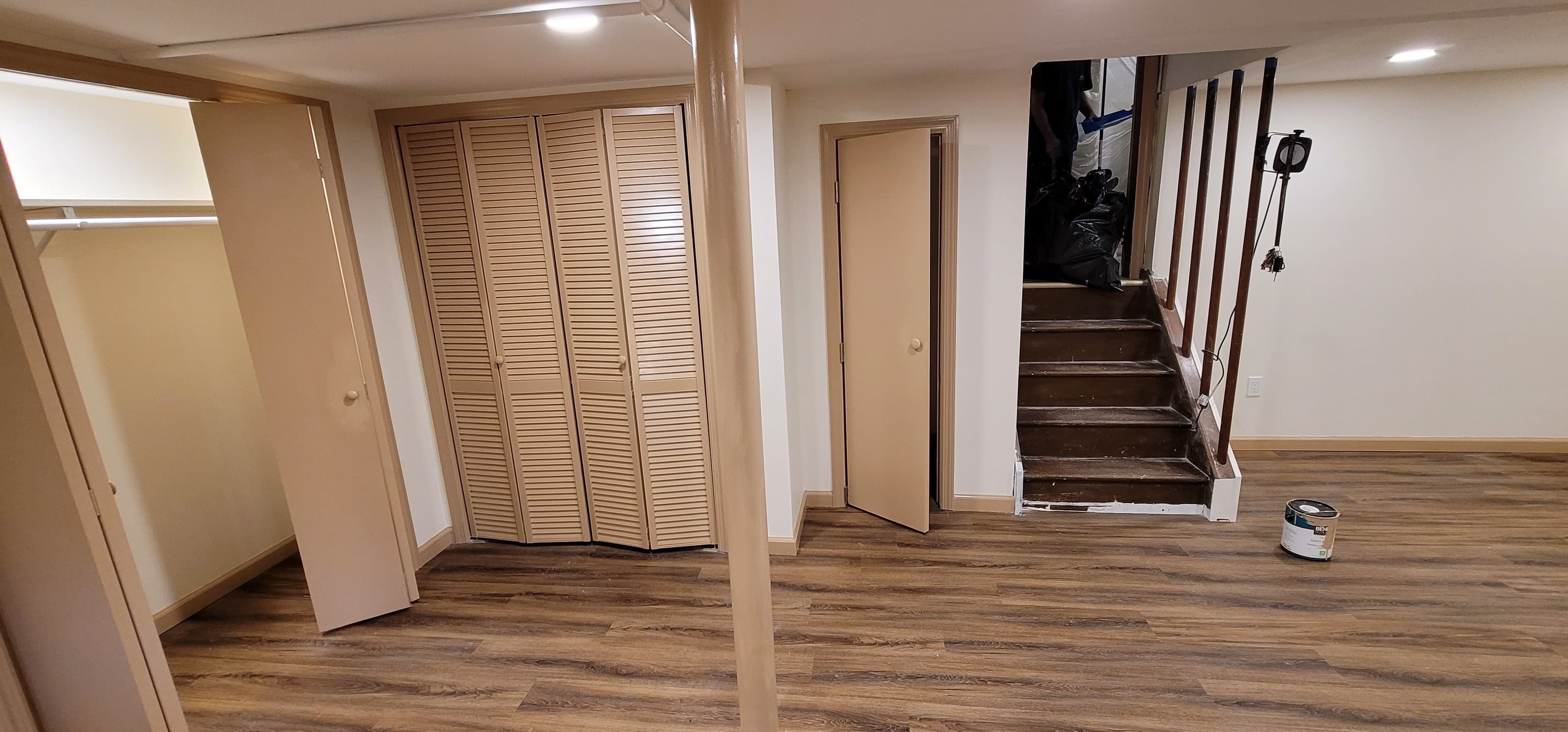 Finished basement with LVP flooring, bi-fold closet doors, open shelving, and staircase, Rockland County NY