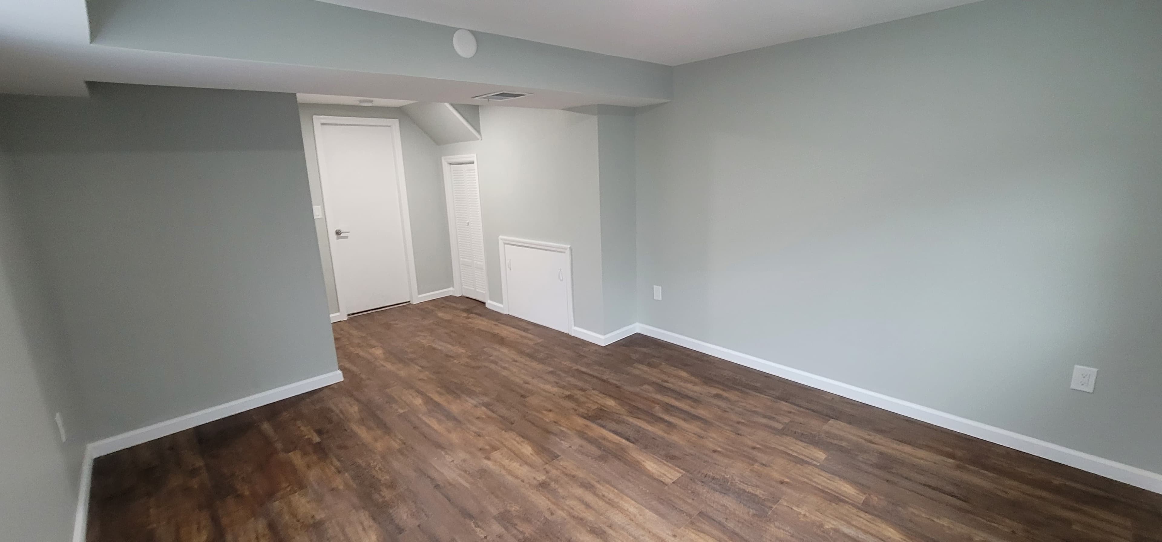 After basement finishing — open-plan with dark LVP and white trim, Rockland County NY