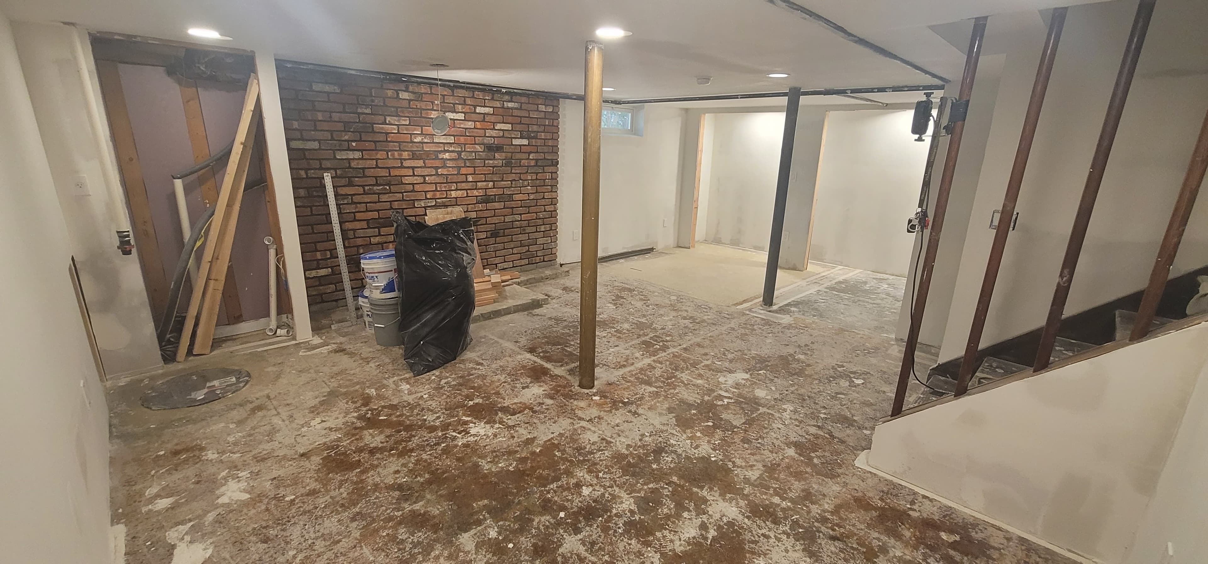 Before basement finishing — raw concrete floor and brick wall, Rockland County NY