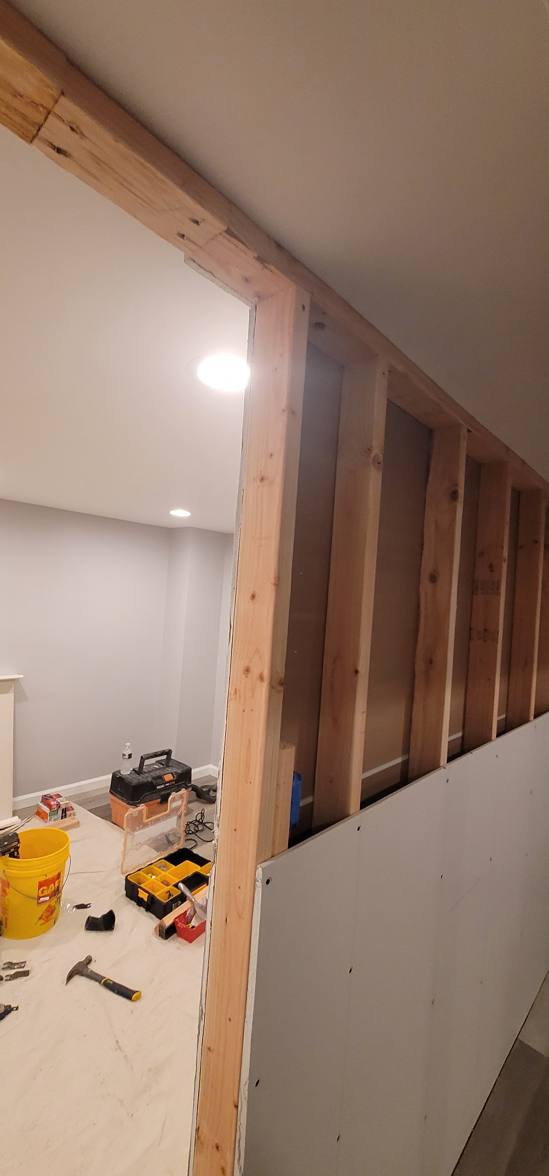 Basement finishing in progress — wall framing, drywall installation, and recessed light rough-in with LVP, Rockland County NY