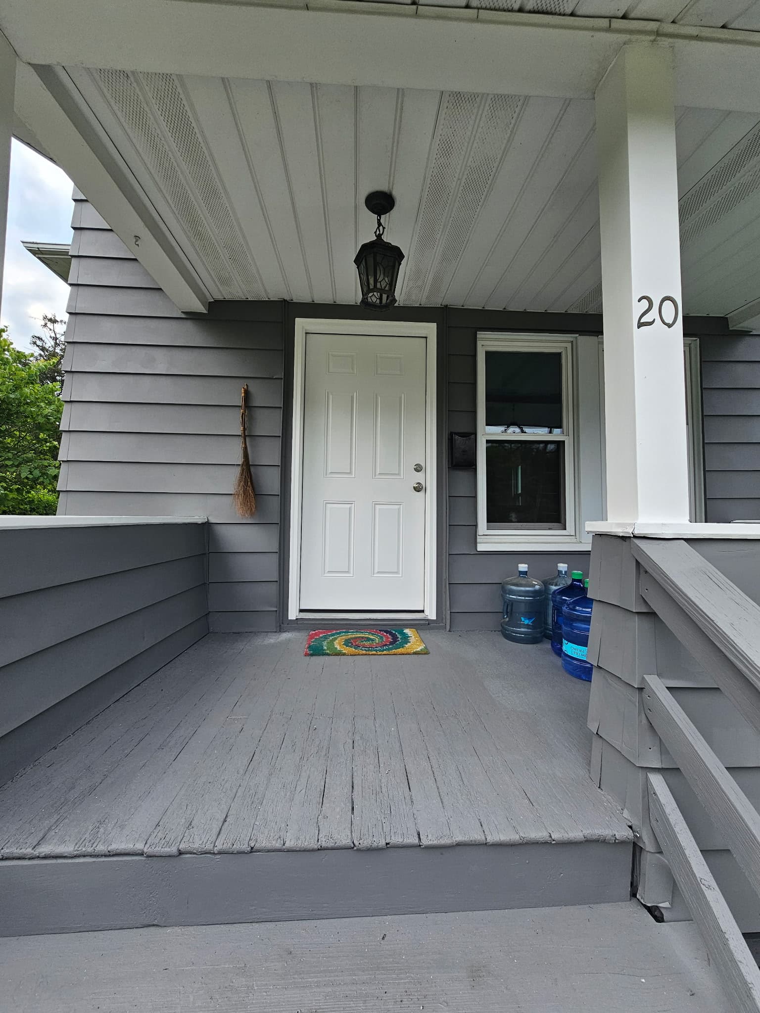 New white entry door installed with gray porch and updated siding, Rockland County NY